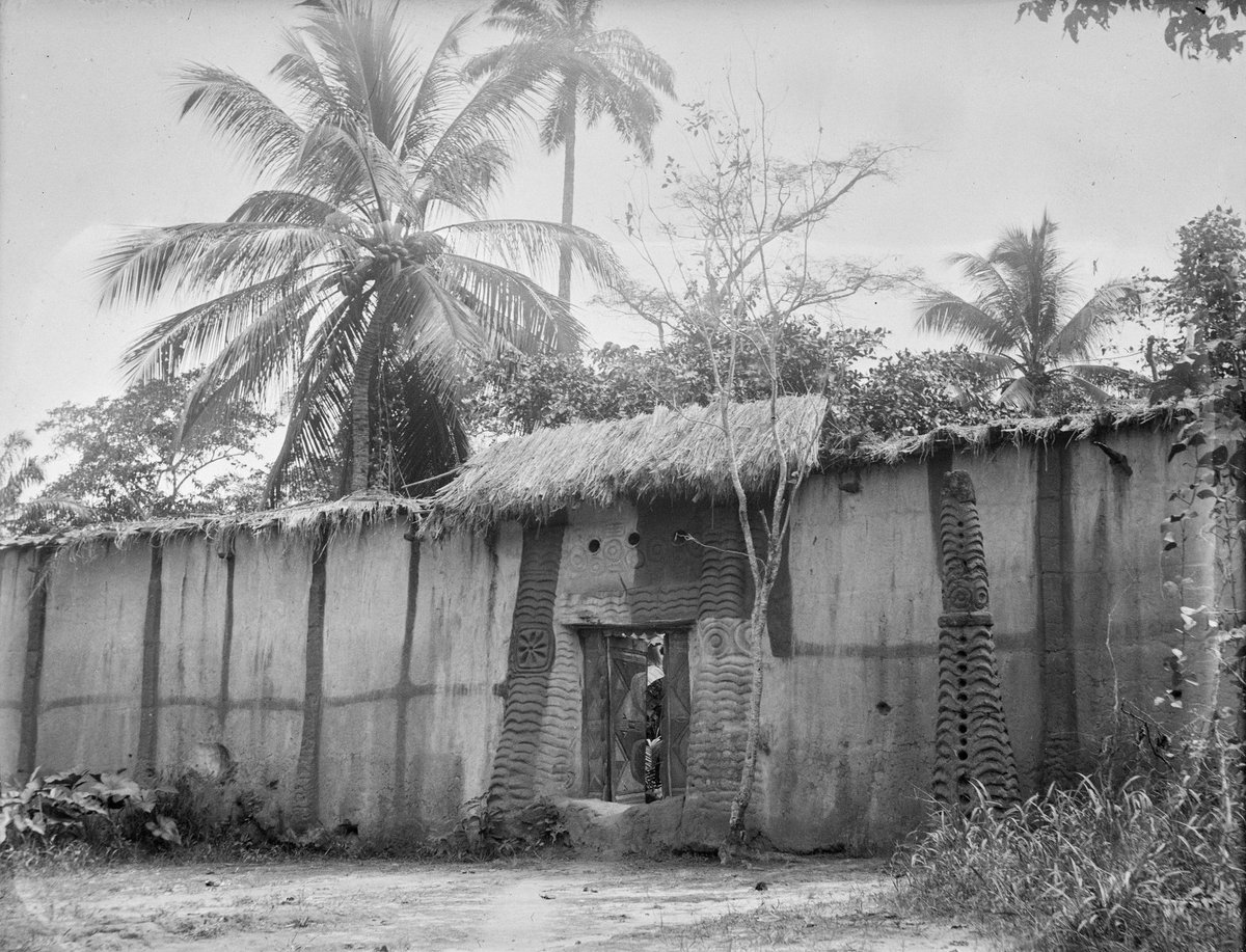 Igbo compound (ngwulu) entrance and high walls (aja ngwulu), in or near Onitsha. Circa 1903-18. Photographed by Herbert Wimberley.