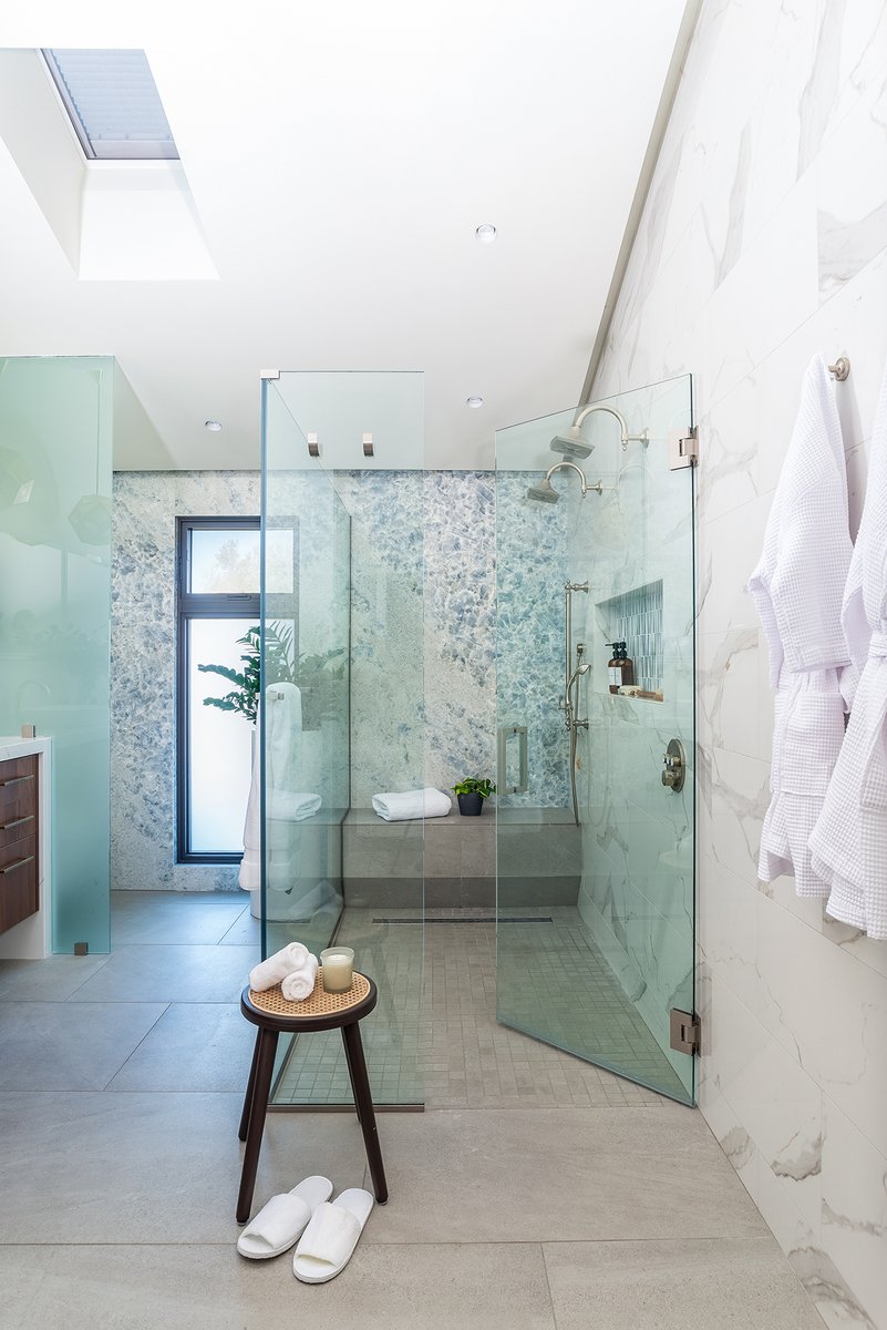 This walk-in shower designed for two radiates serenity with abundant natural light and an abstract backsplash.