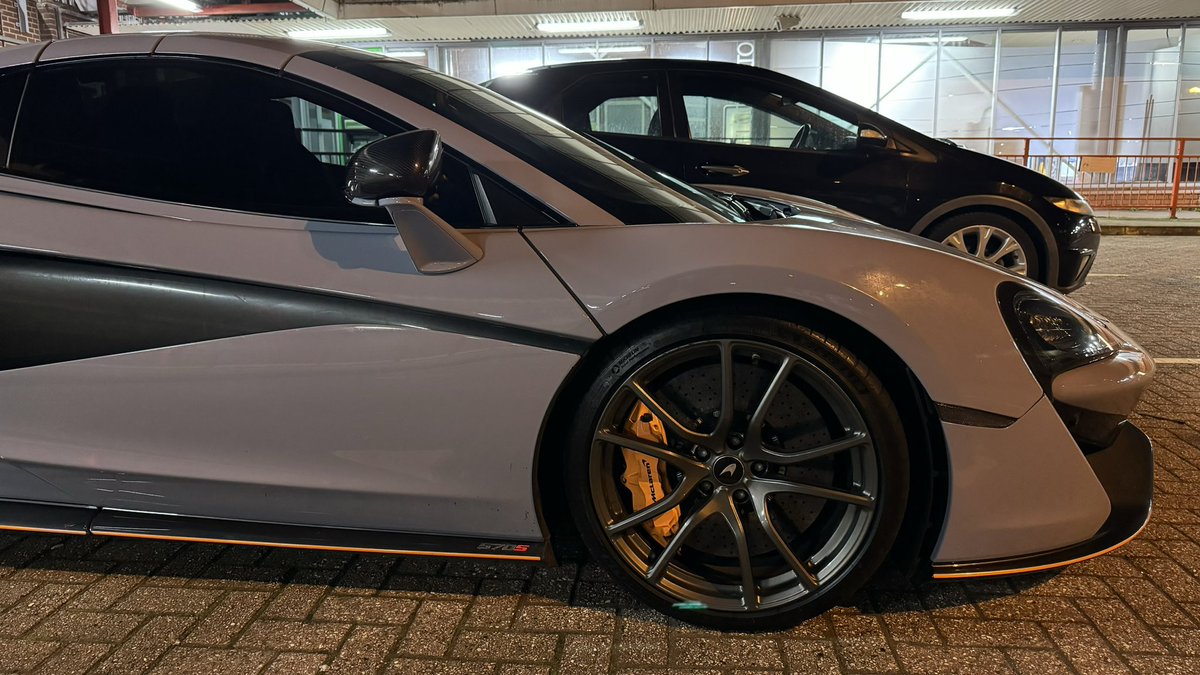 Spotted this grey McLaren 570S sports-car, with orange trim, near Eltham Station in Eltham, South-East London, England - 11th April 2024 Powered by a twin-turbocharged 4.0-litre V8 engine producing 562 BHP 0-60 in only 3.1 seconds, and can reach a top speed of 204 MPH ___