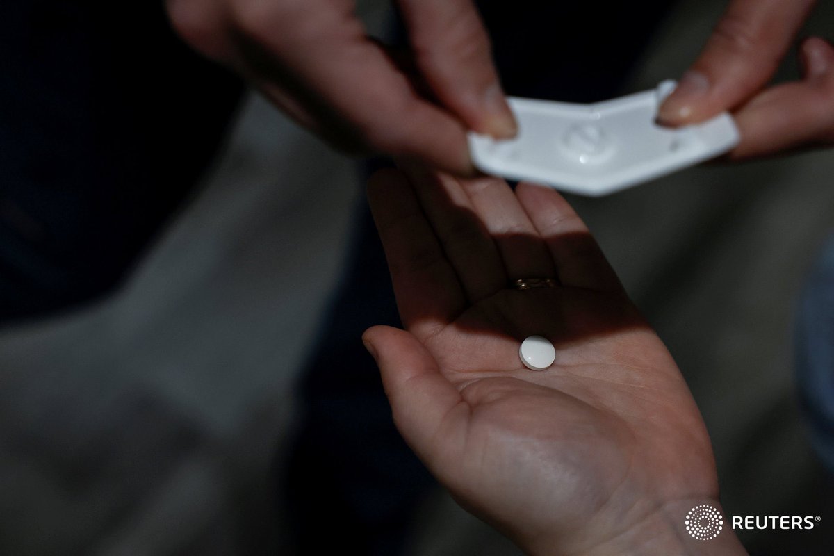 A nurse drops Mifepristone, the first pill in a medical abortion, into a patient's hand at Alamo Women's Clinic in Carbondale, Illinois. Photo by @evelynpix