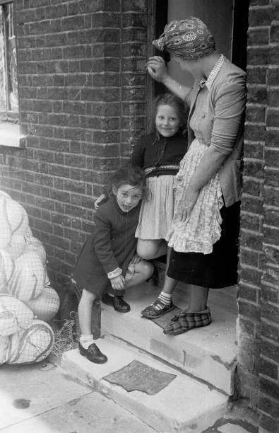 A photograph of a family in the doorway of their house in Morpeth Street in London's East End, preparing to celebrate the coronation of Queen Elizabeth II taken in 1953.