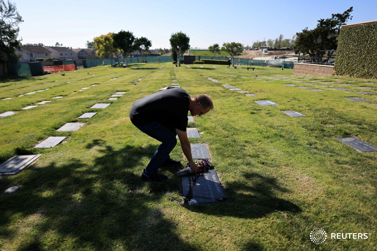 A man touches the flowers on the grave of Nicole Brown Simpson, former wife of American football star and actor O.J. Simpson, after O.J. Simpson's death was announced by his family, in Lake Forest, California. Photo by @SwansonPhotog
