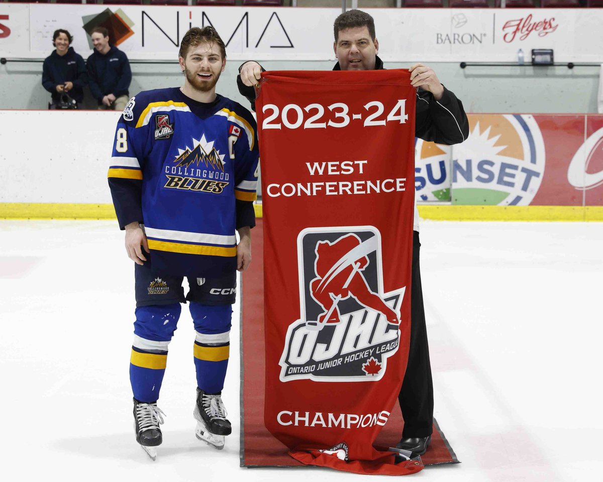 LEAMINGTON, ON - APRIL 11: OJHL Director of Officiating Rob MacGregor presents Collingwood Captain Dylan Hudon #8 the Western Conference Championship banner at the Nature Fresh Farms Recreation Centre on April 11, 2024 in Ontario, Canada (Photo by Tim Bates / OJHL Images)