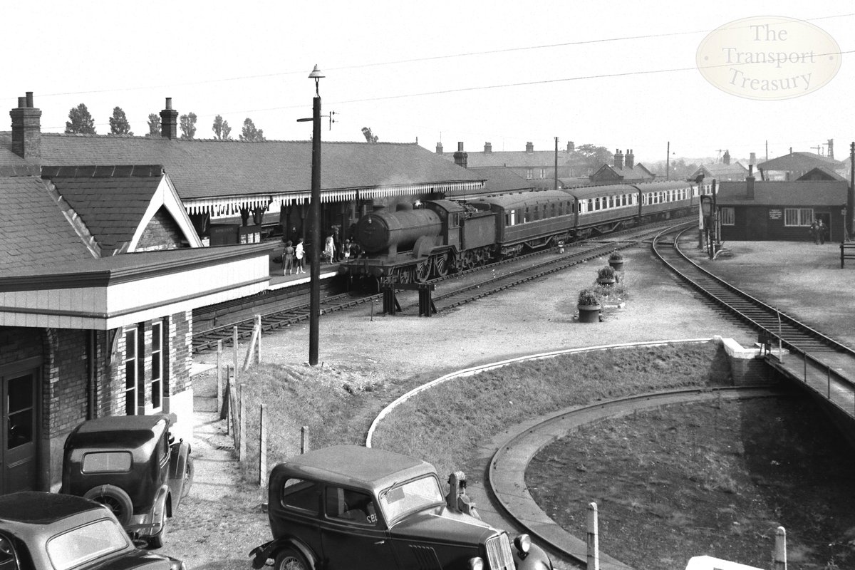 Image found in 'Around the Midland and Great Northern Joint Railway' shorturl.at/rJT06 🚂

'The 12.45pm Yarmouth-Peterborough service rolls into Melton on 26th August 1958, behind class D16/3 No 62524. Lord Hasting's private waiting room can be seen on the left.'