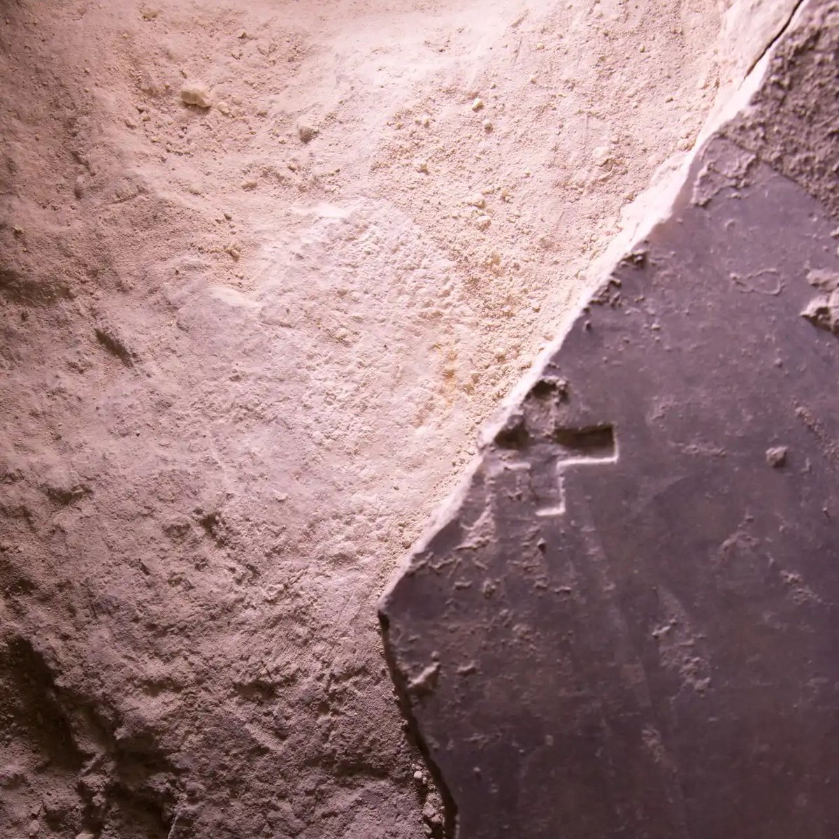 This is what they found: • A marble slab with a cross carved into it • A layer of mortar beneath • A bed carved into the original limestone rock wall