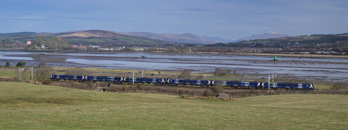 A @ScotRail Class 380 rails alongside the Clyde, passing Dumbarton Rock and Ben Lomond.