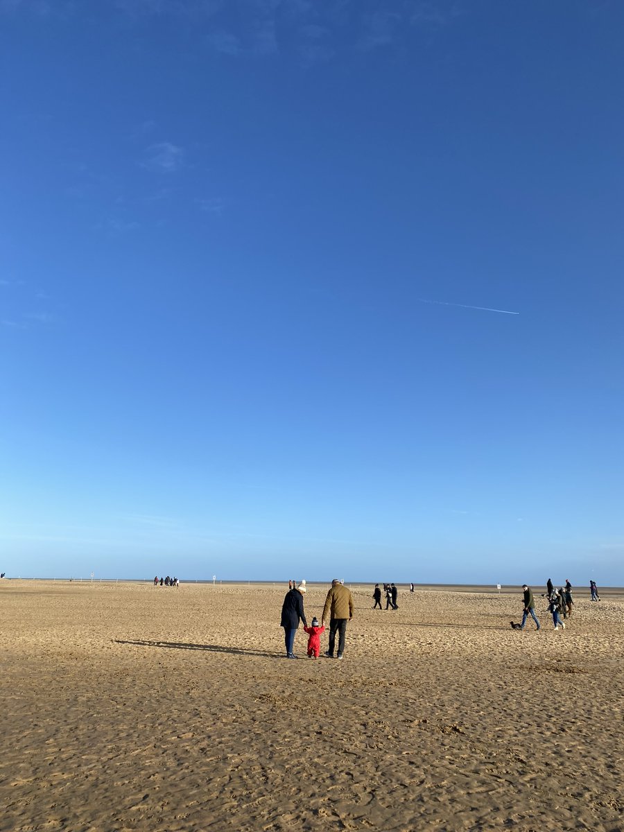 Whether you're a seasoned beach lover or it's your first steps on the sand, the North Norfolk Coast is the place to be✨💛 Image description: Two people hold hands in with a small child in red overalls as they walk on Wells Beach under a clear blue sky. #NorthNorfolkCoast