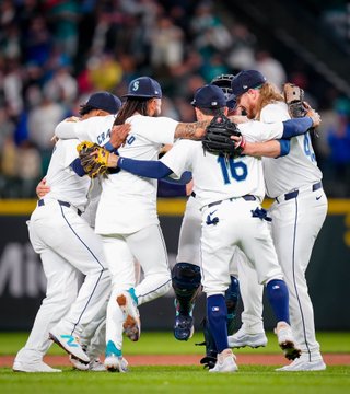 The Mariners infielders dance near in the infield after the win.