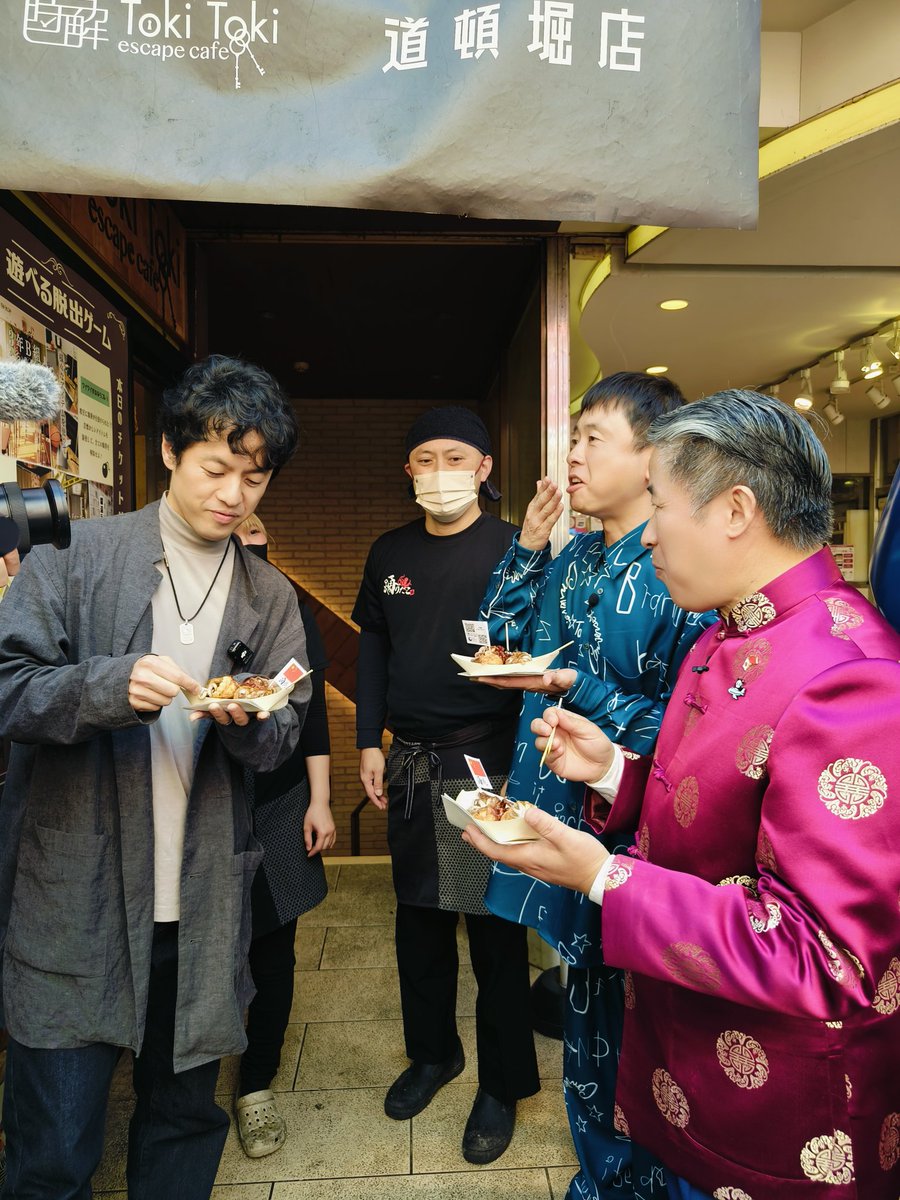 xuejianosaka's tweet photo. ＃大阪道頓堀「がち中華」食べ歩き!（1/2）昨日はいい天気に恵まれ、ドキュメンタリー映画「劇場版　再会長江」で話題を呼んでいる有名な監督竹内亮さんと吉本興業お笑いコンビ「次長課長」の河本準一さんを招き、「天下の台所」を誇る大阪随一の繁華街ーー道頓堀でがち中華を食べ歩いてきた！🤗🤗🤗賑わう一般観光客の皆さんと親しく挨拶を交わしながら、麻辣燙、火鍋のほか、中国風味のたこ焼き、お好み焼き、冰糖葫芦などを味わい、中日文化の異同や民間交流による相互理解の増進など様々な話題について盛り上がっていた。🎊🎊🎊久しぶりの道頓堀だという河本さんだが、至る所に大勢のファンが集り、その驚異的な人気振りをリアルに体感させて貰った。👍👍👍現在動画製作中!お楽しみに😉