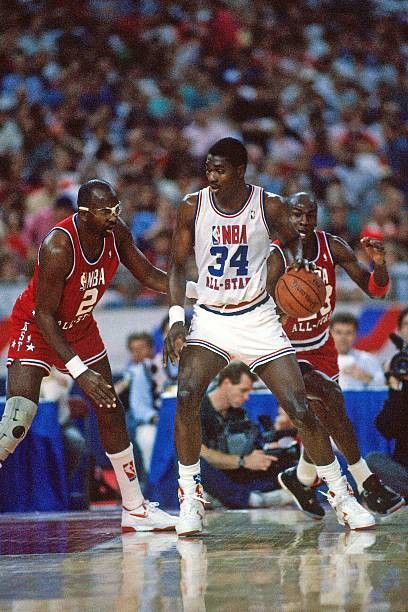 Michael Jordan goes for the steal as Moses Malone guards Hakeem Olajuwon in the All-Star Game.