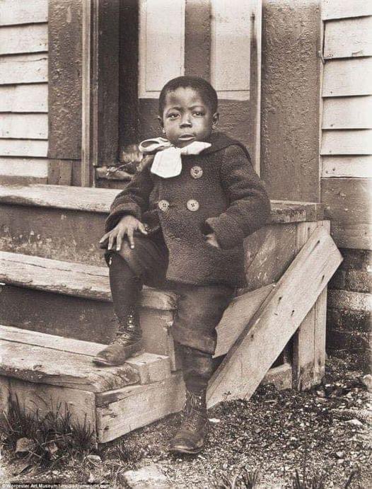 A young boy dresses up to have his photo taken, circa 1905.