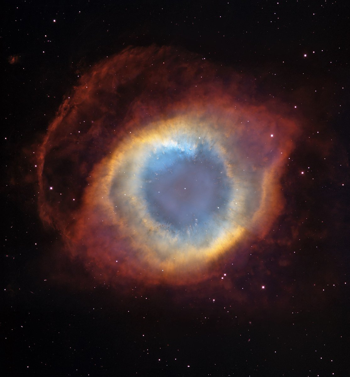 The startling Helix Nebula, a planetary nebula in the constellation Aquarius. A planetary nebula is the last gasp of a lower-mass star that has puffed off its tenuous outer layers. You can see the exposed core of the star as a small white dot in the center of the nebula.…