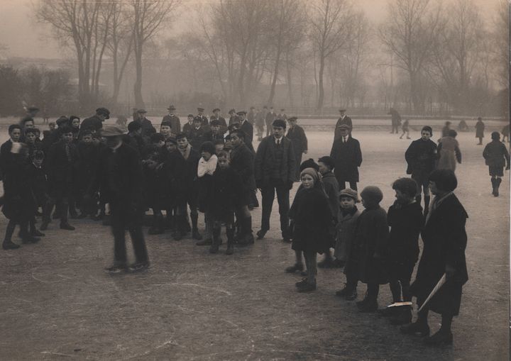 Children watching an ice skater on the frozen pond at Victoria Park, Dec 1925. Archive ref: D-PK13/30