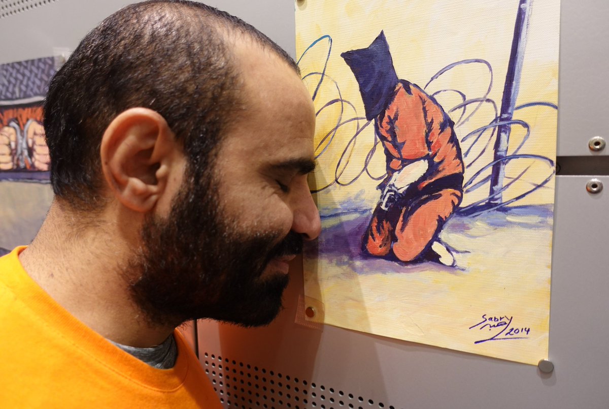 This is Mansoor Adayfi, held at Guantanamo for 15 years, touching for the first time since he left an artwork made by another detainee to illustrate their degredation. Neither were ever charged with a crime.