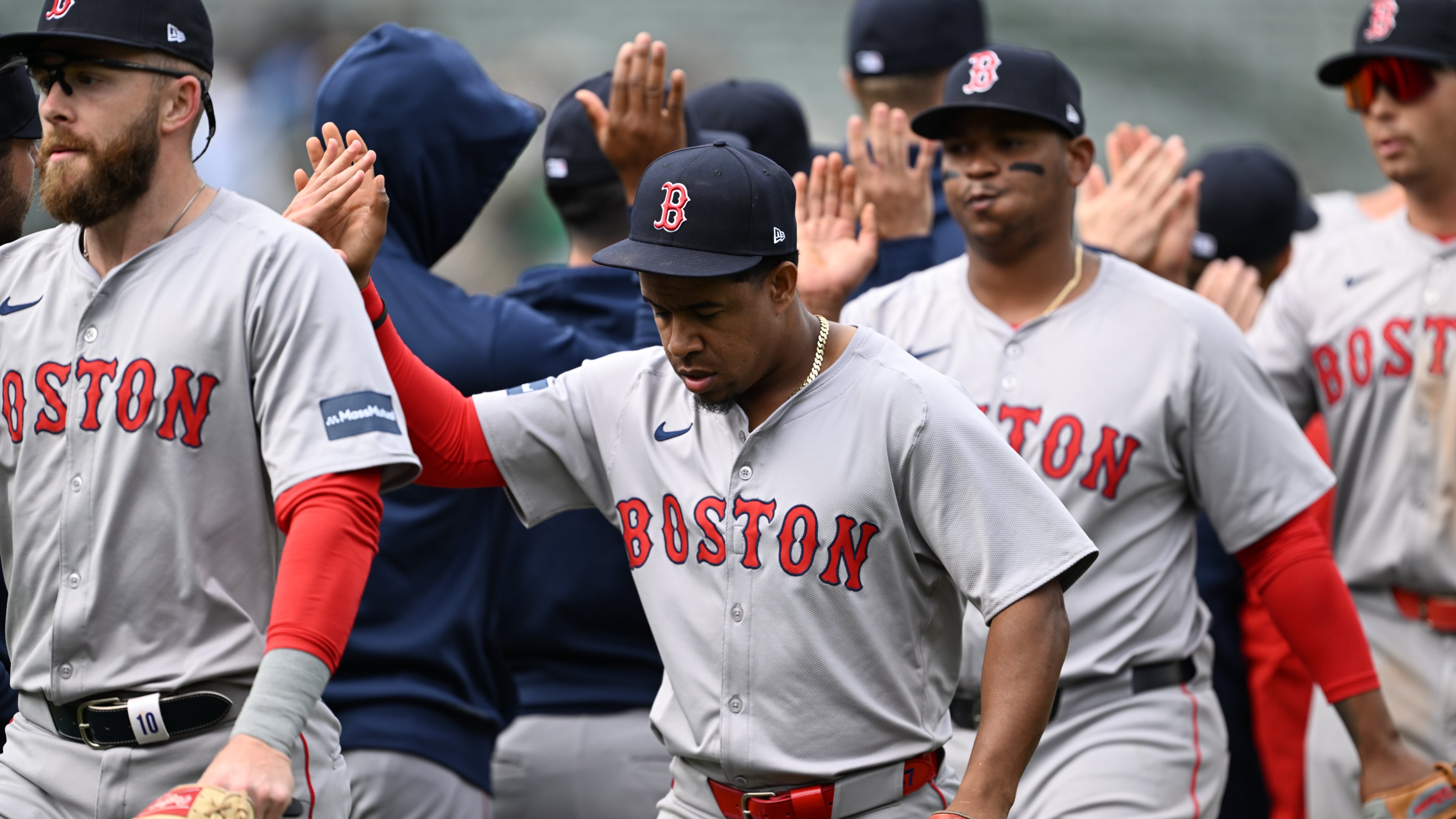 Trevor Story, Enmanuel Valdez, Rafael Devers, and Triston Casas line up and high-five teammates following the win. 
