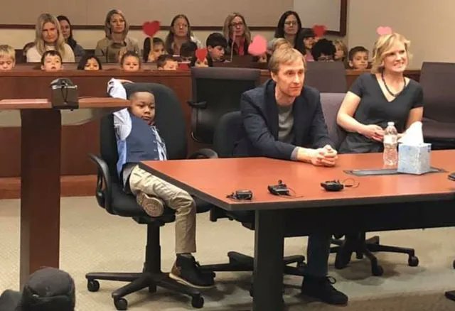 In Grand Rapids, Michigan, a heartwarming scene unfolded at the courthouse during a boy's adoption hearing. Five-year-old Michael, accompanied by his foster parents, was surrounded by an unexpected group of supporters – his entire kindergarten class. Each child held up large red…