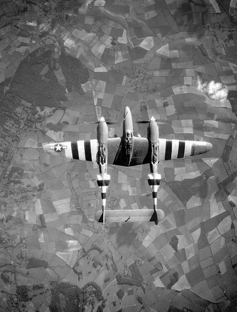 Top view of a Lockheed P-38 Lightning fighter aircraft in flight over the English countryside in June, 1944. #History #WWII