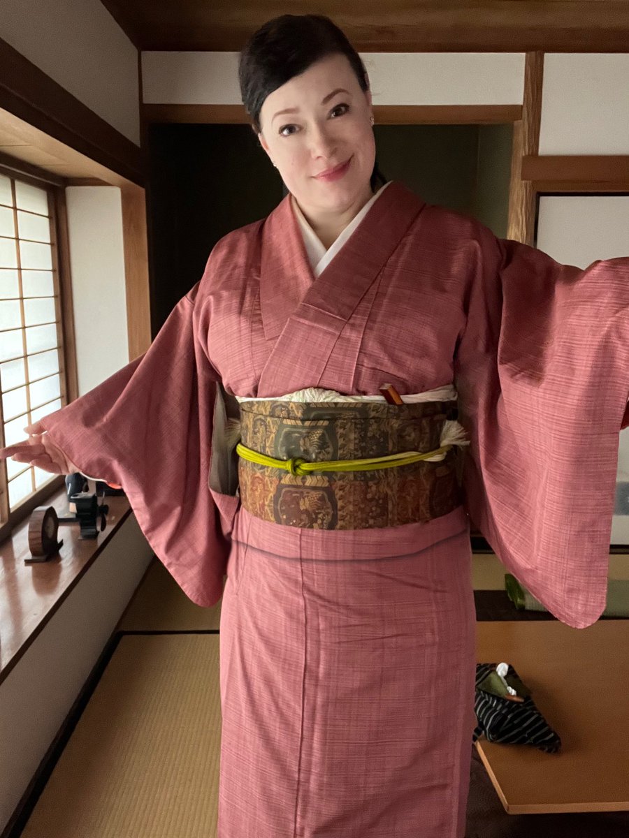 Good morning. Today I’m off set, so I’m wearing a sakura-colored Yuki-Tsumugi (結城紬) kimono with green highlights in the obiage (帯揚). Notice that in much Japanese color coordination, brown fills in where western sense would call for black.