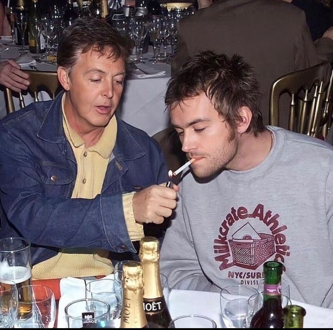 Paul McCartney enciende el cigarrillo de Damon Albarn en los NME Brat Awards en el Mermaid Theatre de Londres, 2000