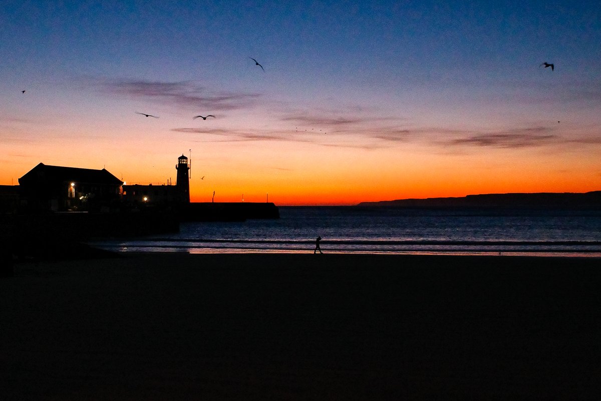 An absolute stunning sunrise taken from our @RNLI Boathouse before some morning training few weeks back. The colours were amazing and the silhouettes of #Scarborough lighthouse and the guy on the beach really add to the photo. Taken with my #Ricoh GRiii