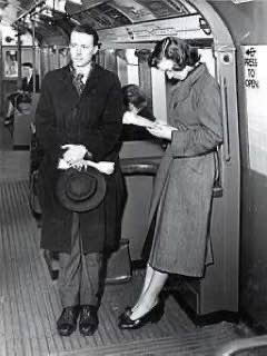 A photograph of a Couple taking the London Underground in the 1950s.