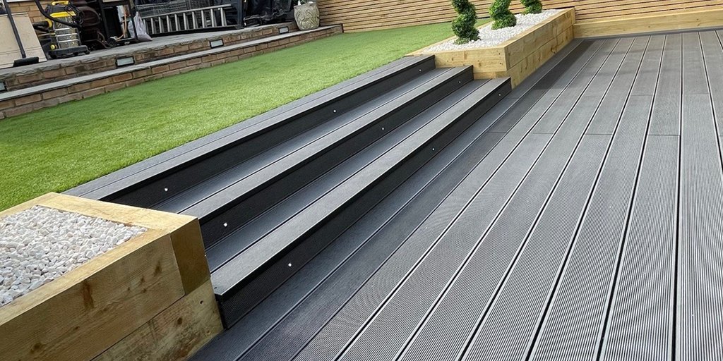 We're loving these smart composite grey decking steps leading to another level in this garden design!