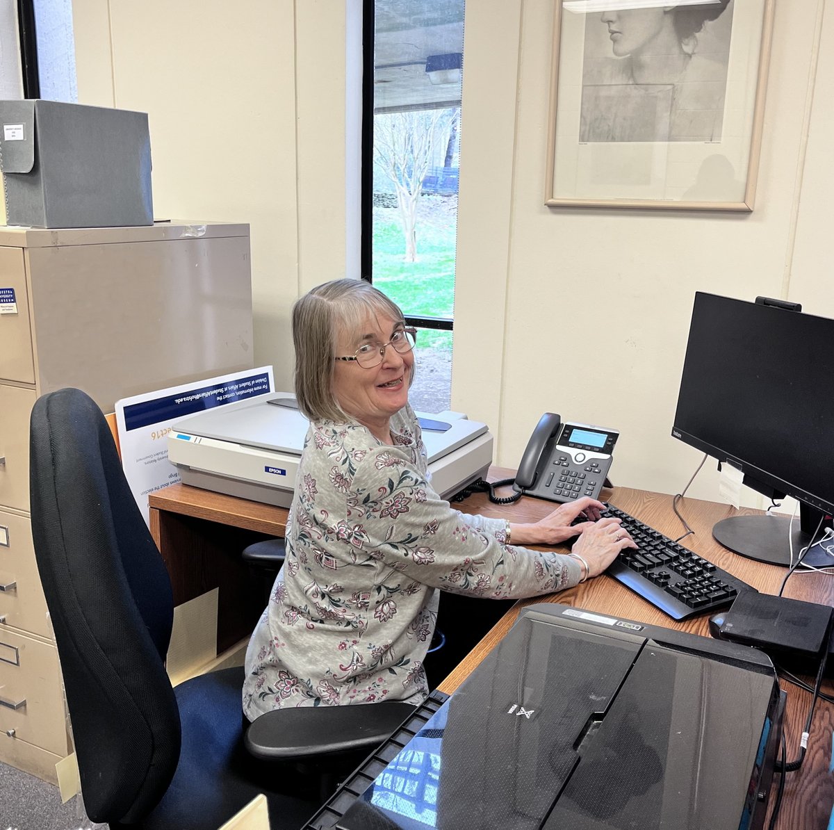 Looks like you can go home again! Yes, that's Vicky Aspinwall sitting at her old desk in our reading room. We're thrilled to have her back as a part-time volunteer!