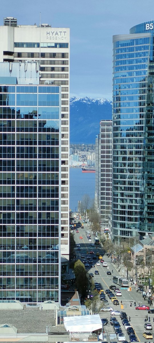 Beautiful day in Vancouver and I have a great view from my hotel room. Tall buildings, a harbour and mountains with snow on top in one photo. バンクーバーはいい天気。ビルも海も山も見える。