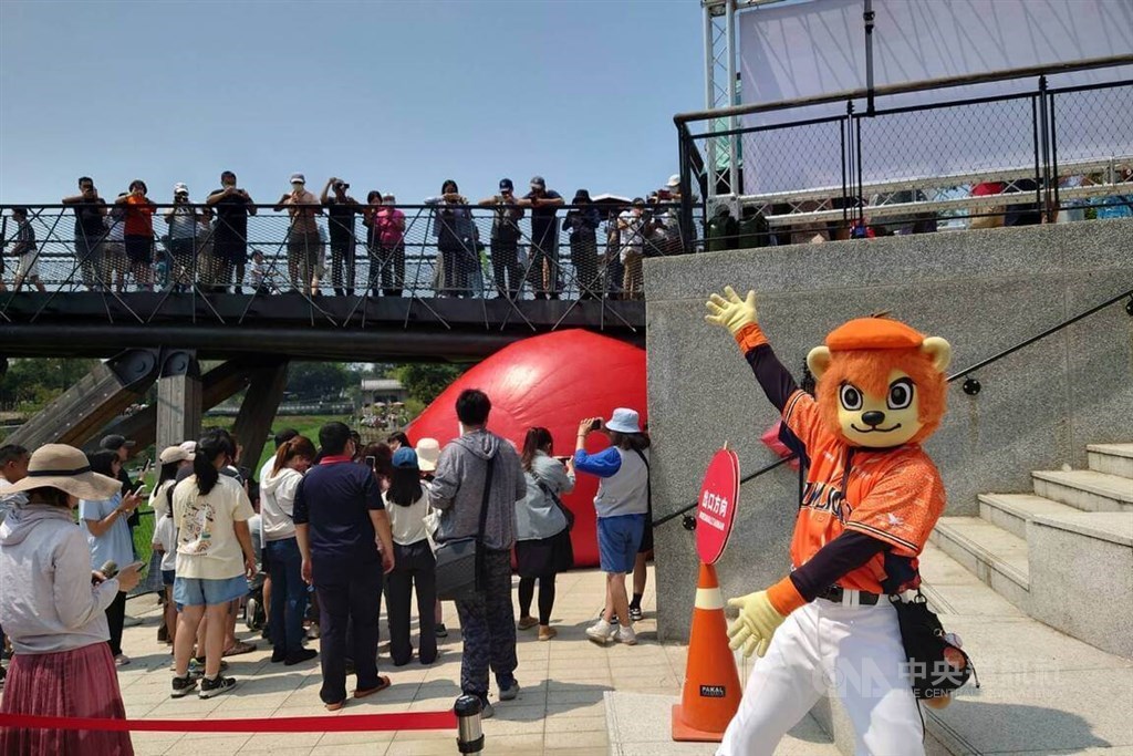 Focus_Taiwan's tweet photo. REDlocation Day 9: American artist #KurtPerschke's "#RedBallProject," appears underneath Tainan's Zhu Xi Moon Viewing Bridge on Saturday. The attraction is the latest stop in the ball's 10-day journey across the southern city. https://t.co/NVZ0X0wO2d https://t.co/js9GzSYKZO