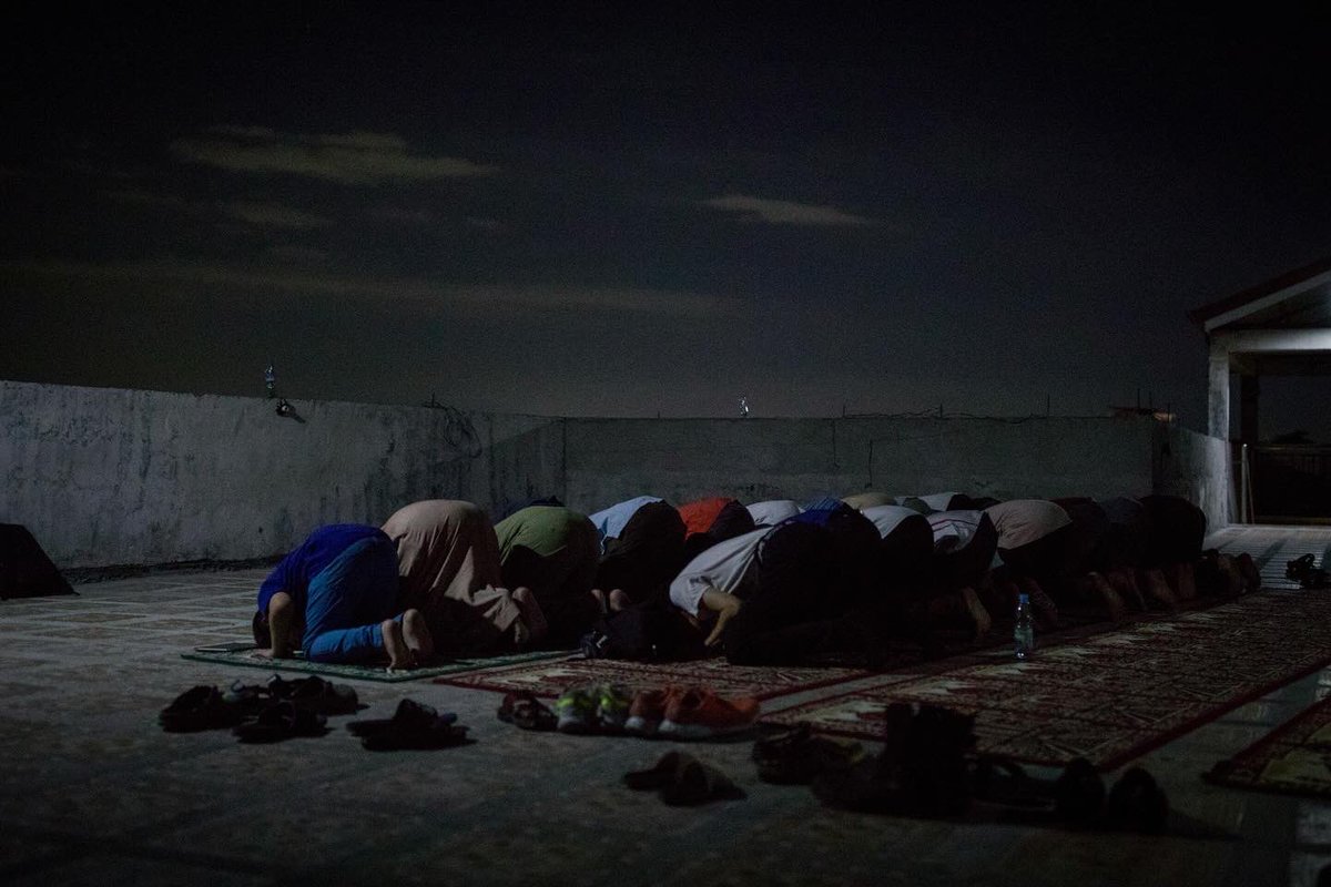 Palestinian refugees, along with fellow Muslim Filipinos, perform their evening prayers, Taraweeh, after breaking their fast during the last days of Ramadan at Little Gaza, Quezon City.