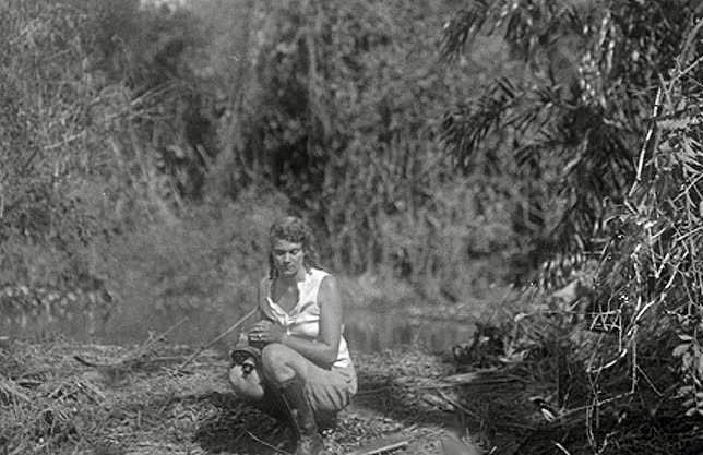 1930-31, Adventuress, Aloha living for 6 weeks with a Stone Age tribe, the Bororos in Amazon jungle. Here Aloha is watching all around and being very careful around the watering hole. You never know what danger is around the corner. Remarkable woman. AlohaWanderwell.com RDT