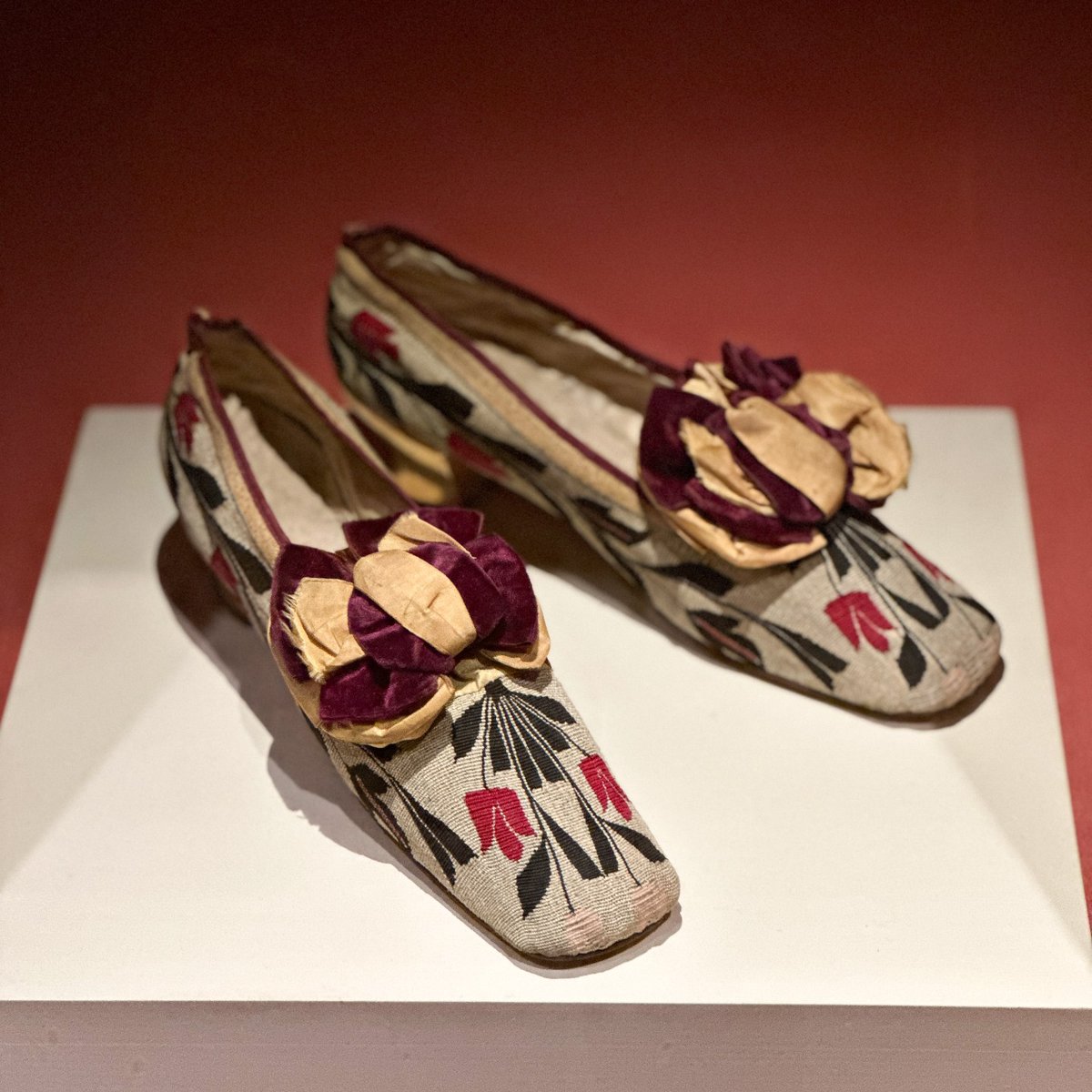 This pair of women's shoes dates to the late 1870s or early 1880s and features uppers made of Turkish kilim, hand-woven textile originating centuries ago. The textile used to make this pair features black and red tulips 🌷