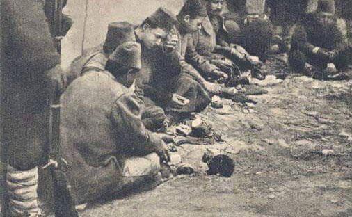Kendine verilen bir parça ekmeği kedi yavrusuyla paylaşan esir düşmüş bir Türk askeri. Balkan Savaşı, 1912.