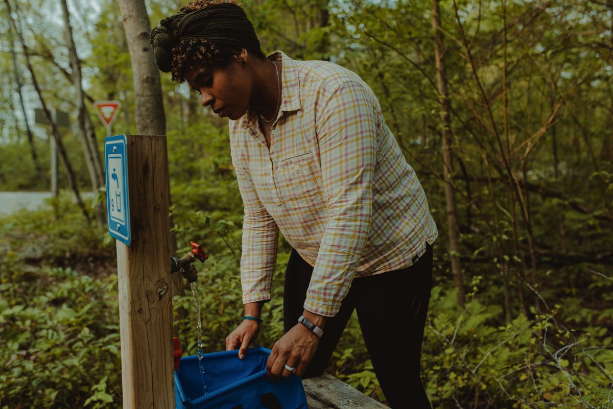 ‼️ Water Update ‼️ . ✔️All taps, comfort stations and trailer dump/fill stations are fully operational. 💦 . Enjoy your first weekend of 2024 camping at Rondeau! ⛺️ #visitck [Image: Visitor fills blue container with water at a water tap in the forest.]