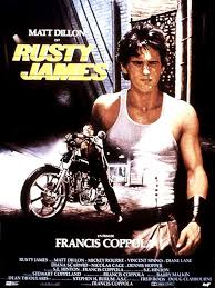 merlinpapin3's tweet photo. .@FredOL69007 .@tbarnaud Dans le cadre des #MilleFilmsdemaVie, je vous propose #RustyJames (Rumble FIsh) de #FrancisFordCoppola (1983) avec Matt Dillon, Mickey Rourke, Vincent Spano, Diane Lane, Nicolas Cage, Dennis Hopper, Chris Penn, Sofia Coppola, Lawrence Fishburne.
En l'absence de Motocycle Boy (Rourke), son frère aîné, Rusty James (Dillon) n’hésite pas à affronter lui-même un chef de bande rivale (Spano). Il sera sauvé par le retour de son frère, un être désabusé fasciné par les poissons s'acharnant contre leur propre reflet.
Pour plusieurs raisons et pas des moindres, parce que c'est un film de Coppola et je suis entièrement fan de ce réalisateur que je n'ai malheureusement vu que de loin au Festival de Deauville, parce que le film réalisé après (voir en même temps) que son film The Outsiders qui est pour moi un must, car il est adapté du même auteur que The Outsiders, Susan Eloise Hinton, ou dans les deux films il y a la même approche l'adulation d'un jeune pour son grand frère, thème qui a été une ligne de conduite souvent chez Coppola jusqu'à Tetro.
Parce qu'il a gardé la même équipe technique que The Outsiders, et surtout plusieurs des comédiens Diane Lane, Sofia Coppola (sa fille) et Tom Waits et surtout dans le rôle-titre , un garçon dont j'étais fan dès que je j'ai vu Tex et encore plus The Outsiders , le génial et bombe Matt Dillon que je n'ai jamais lâché malgré sa courte traversée du désert et 40 ans après il est toujours et lui j'ai eu la chance de le rencontrer pour mon premier Festival de Deauville.
Pour le respect que l'on peut avoir pour un réalisateur de cette trempe qui après des succès monumentaux autant critiques, palmarès et public (Apocalypse Now et la Trilogie du Parrain) a su faire des faires des films avec plus de calme et des budgets moindres tout en gardant sa qualité.
Pour la beauté des images sublimes en noir et blanc avec pour seul couleur rouge des poissons et un phare de la police qui explique que la comédie de cette violence est finie. Beaucoup de rapprochement avec The Outsiders, Hinton n’y est pas pour rien, mais pour moi c'est d'une beauté viscérale.
Stewart Copeland le batteur de Police a écrit un morceau pour le film "Dont' Box Me In".
Si vous aimez Coppola, si vous aimez les histoires de fratrie pas à l'eau de rose, mais à coup de poing et de fidélité c'est pour vous, vous ne serez pas déçu.