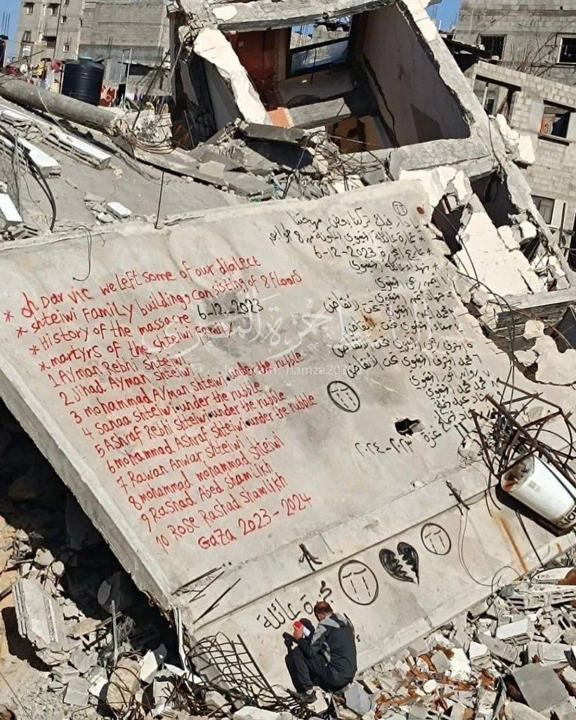 A Palestinian writes the names of his family members buried under the rubble of his home in #Gaza.

#StopGazaGenocide