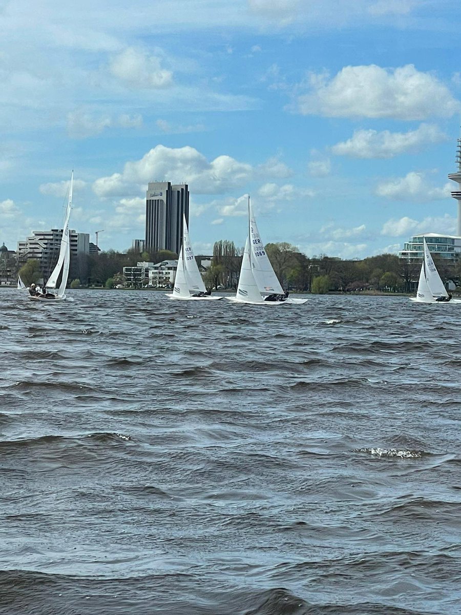 White sails carried by the wind competing in the waters of the Elbe River in Hamburg.