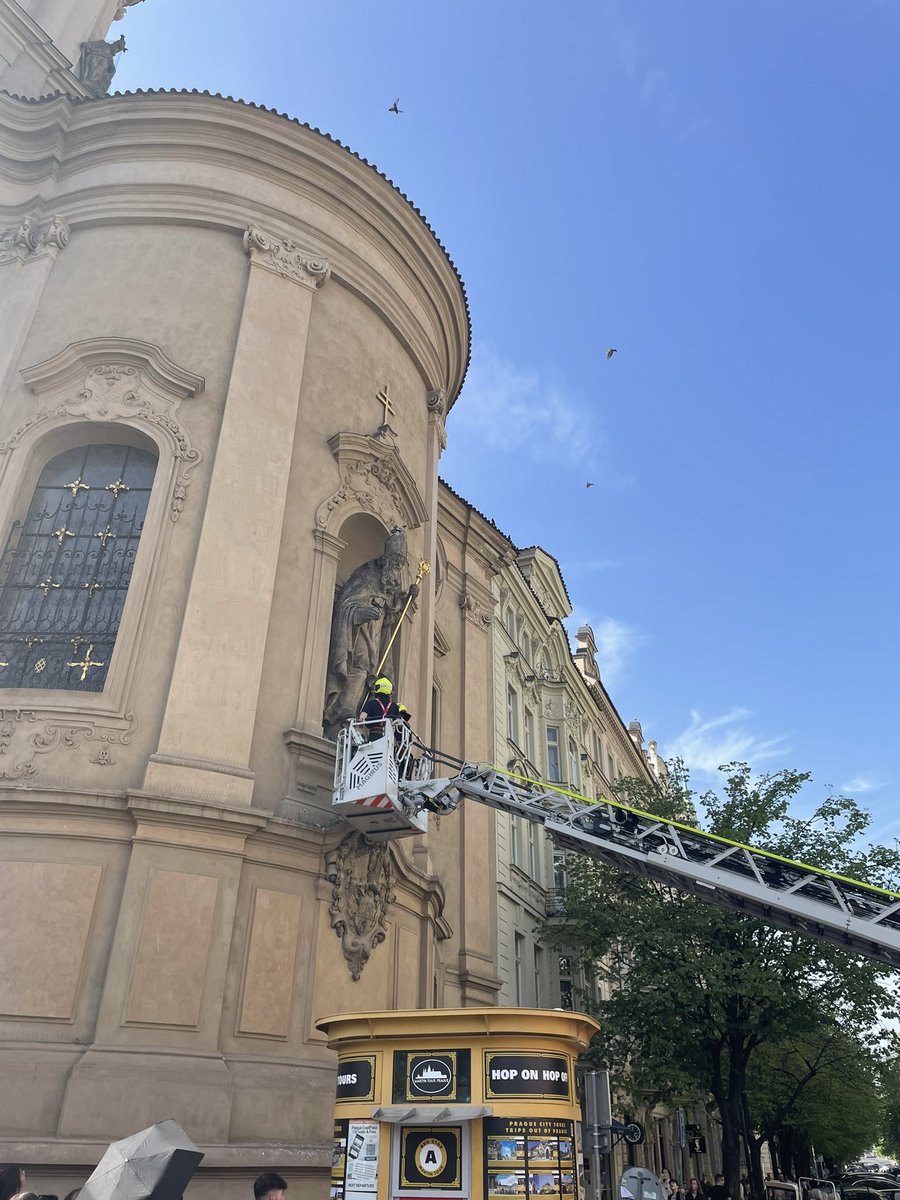 Major traffic jam in central Prague as the fire brigade rescue two pigeons from some netting covering the statue of a saint.