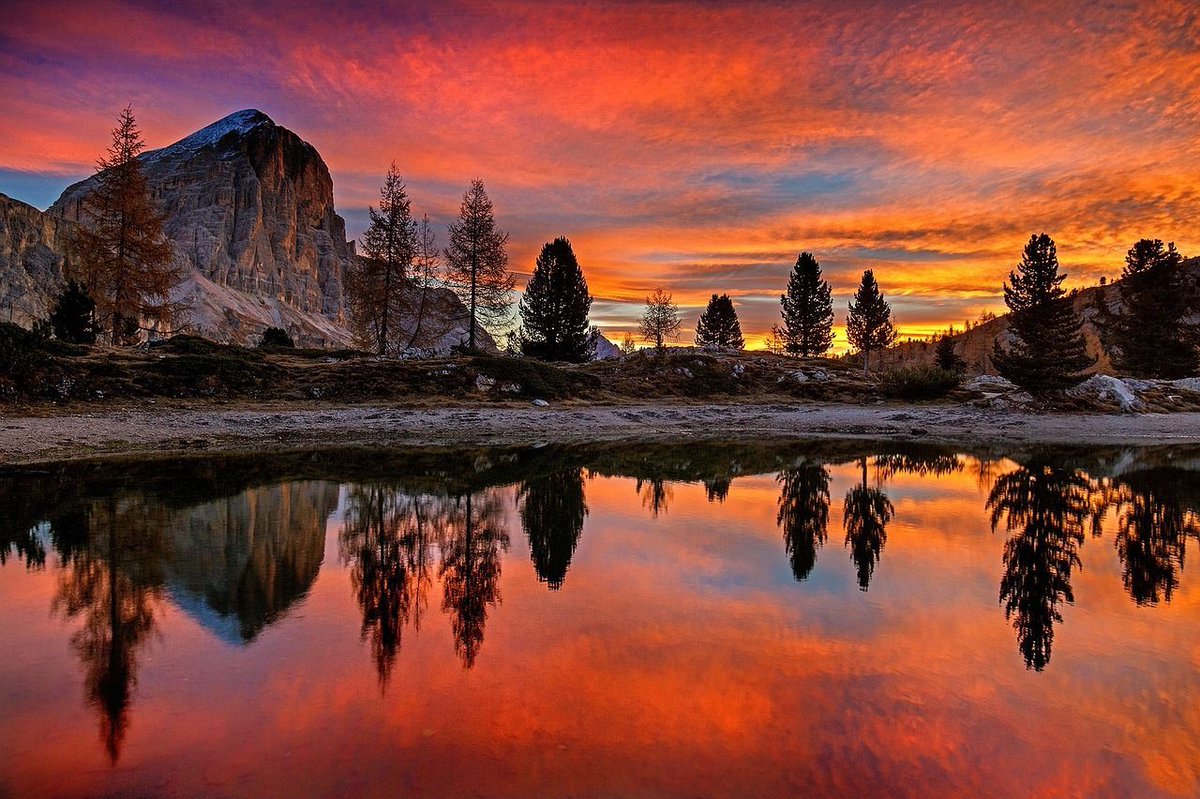 Lake Lìmedes, famous for its reflection of the mountain Tofana di Rozes, certainly looks good in orange 🧡 Tagging @LiveaMemory, @sl2016_sl, @leisurelambie & @FitLifeTravel for #SundaySunsets #Sunset #LakeLimedes #Dolomites