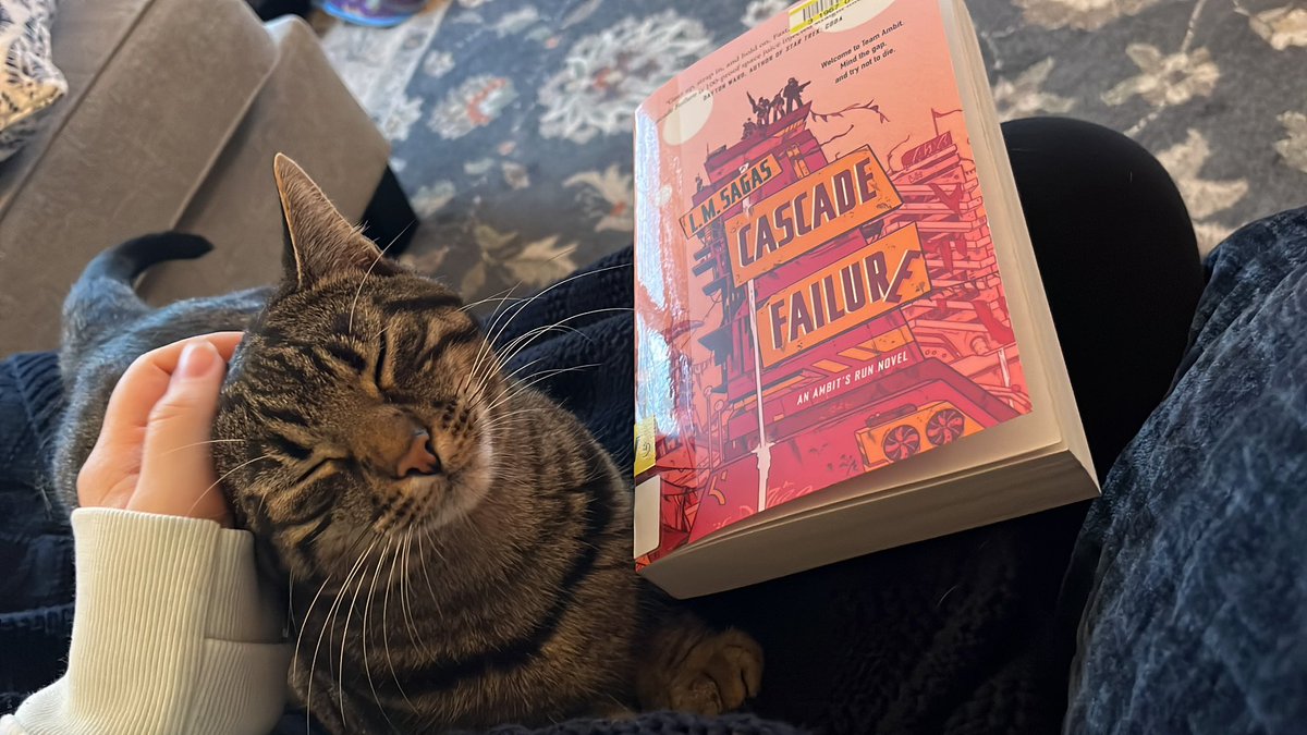 Rainy Sunday afternoon. Very much looking forward to cracking into this novel by @lmsagaswrites - @jsdewes meets Firefly? Say less. Nori is just pleased there is an available lap.