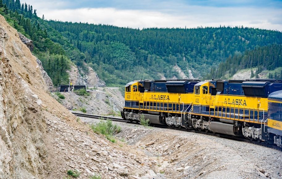 Yellow and black train on rail tracks during daytime in Alaska