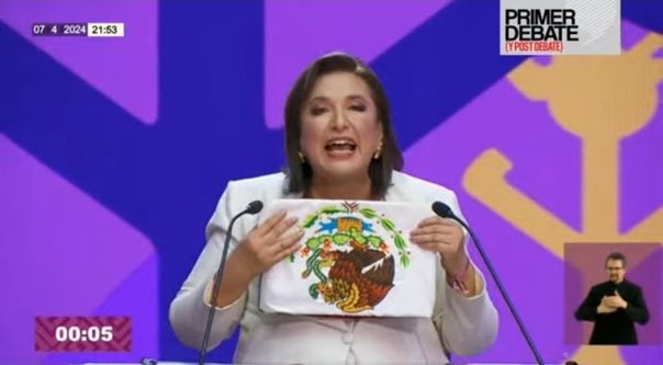 sabinaberman's tweet image. El meme del debate: Xóchitl mostrando la bandera al revés.