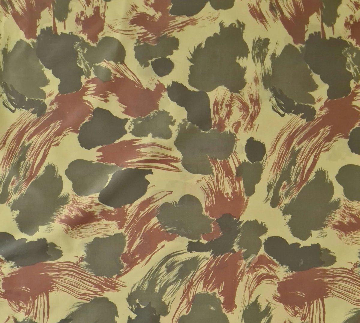 NZ Army Camouflage 1949-1979. The pattern was a unique blend of blotches and brushstrokes, featuring dark green and olive-green blotches, russet brushstrokes, and a lime green background. This design remained in use for over two decades. #ANZACmonth.