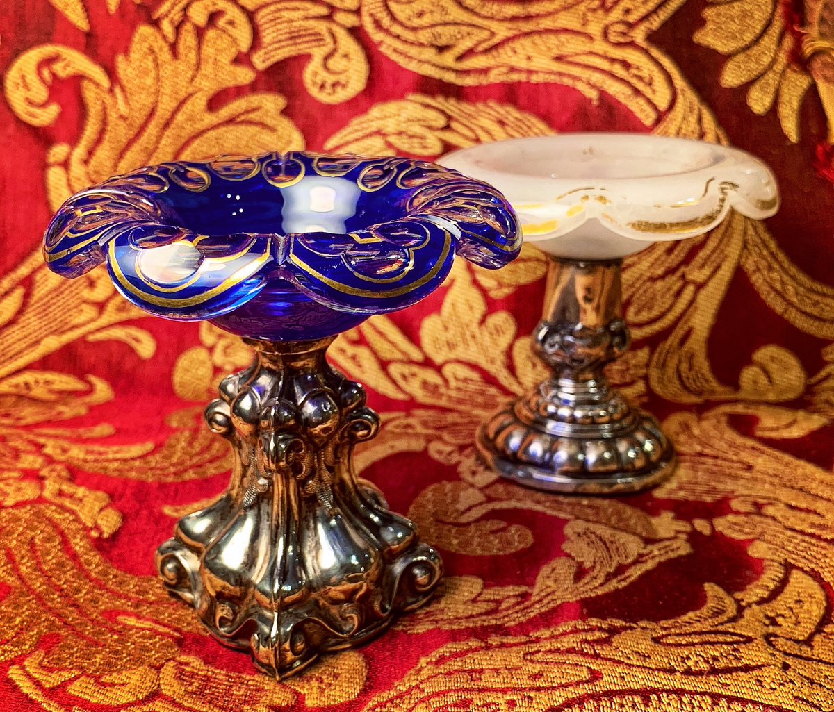 #NotOnlyMuranoGlass ! Who knows which and how many set tables these two small salt holders have embellished, one in layered cobalt blue glass and the other in opaline glass, both on a silver stem from the Biedermeier era?