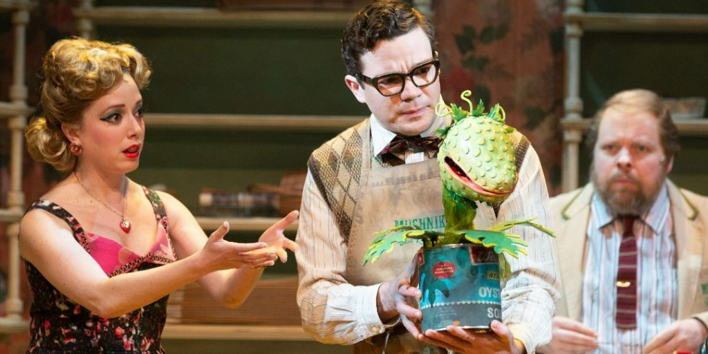 ⚠️Warning: Seymour bought the sinister plant Audrey during a total solar eclipse.⚠️ Gabi Epstein as Audrey, André Morin as Seymour Krelborn and Steve Ross as Mr. Mushnik in Little Shop of Horrors, 2019. Photograph by Cylla von Tiedemann. More credits: ow.ly/w3Zp50Ravvu