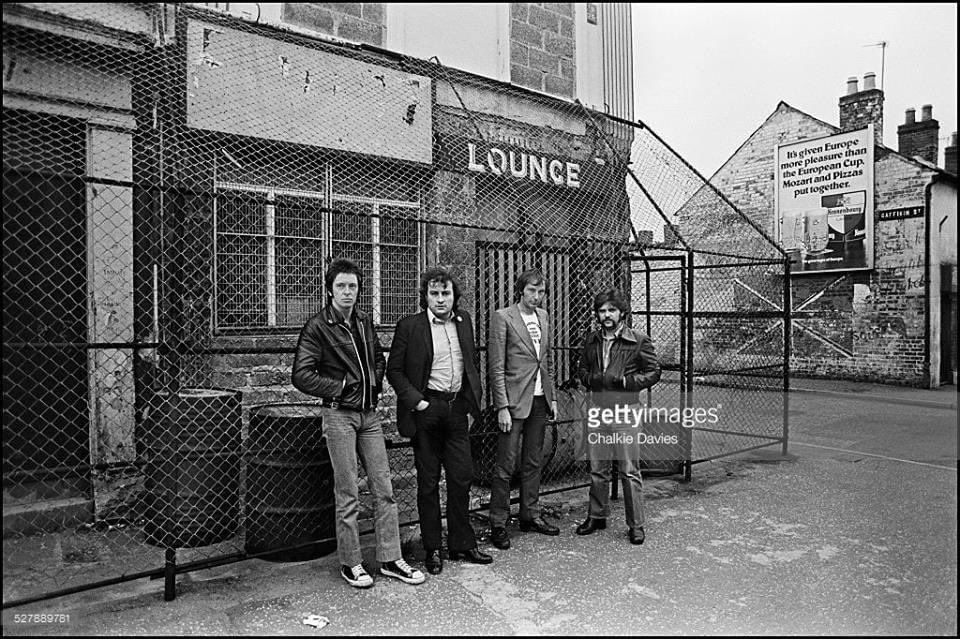 Dr Feelgood in front of the Crescent Bar, Belfast, 1977.  
The cage was used to protect the pub from bomb attacks. 
Few groups came to Belfast because of this.