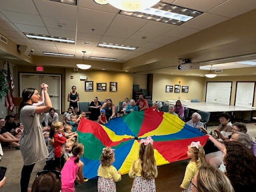 .@NeenahLibrary collaborates with Valley VNA Assisted Living Facility to provide 'Storytime for Everyone.' Participants of all ages enjoy books, songs, movements, puppet shows, parachutes, and conversations. It's a fun time and shows the power of libraries! #NationalLibraryWeek