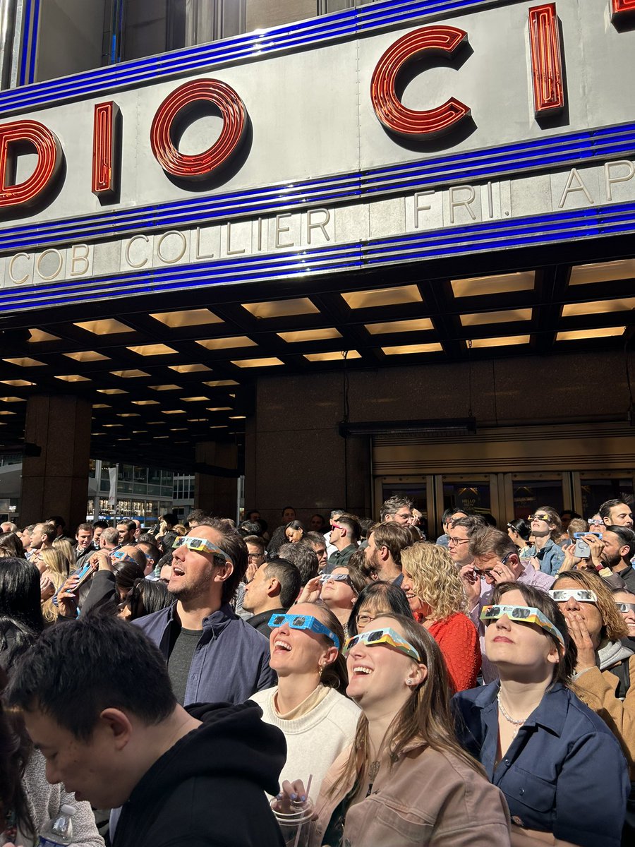 Just look up!🌙 I love New York… Snapped this pic of people watching the eclipse from 6th Ave outside Radio City as I headed into work today. @NBCNewYork