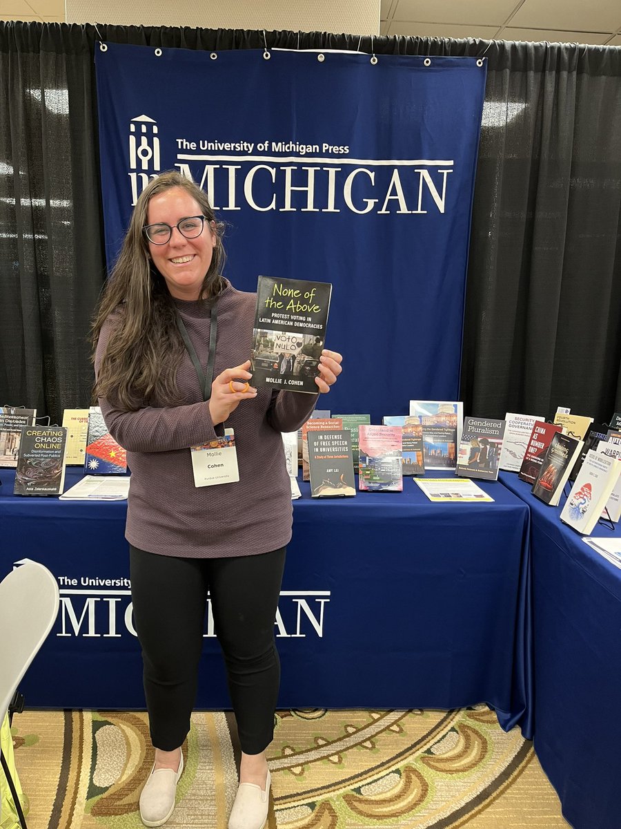 Author sighting at #MPSA2024! It was so exciting to see Mollie Cohen and her book “None of the Above” at the @UofMPress booth on Friday.