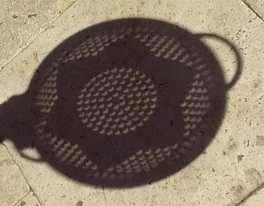 A colander with round holes provides a fun (and safe) way to watch the eclipse!